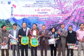 Ban quản lý Công viên Địa chất toàn cầu Cao nguyên đá Đồng Văn tặng hoa, quà và cờ lưu niệm cho những vị khách du lịch đầu tiên. (Ảnh: Minh Tâm/TTXVN) 