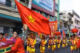Đoàn diễu hành và múa lân-sư-rồng đi qua các tuyến phố từ chiều tối, tạo nên không khí sôi động. (Ảnh: Phương Vy/TTXVN)