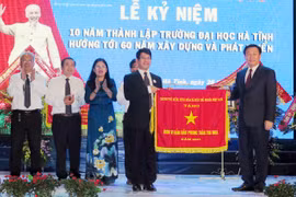 Phó Thủ tướng Vương Đình Huệ tặng Cờ thì đua của Chính phủ cho nhà trường. (Ảnh: Công Tường/TTXVN)