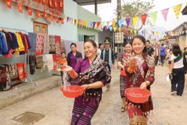 Những cô gái dân tộc Lào té nước cầu may. (Ảnh: Xuân Tư/TTXVN)