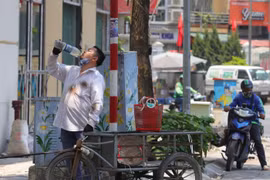 Một người dân bổ sung thêm nước khi phải di chuyển dưới cái nắng, nóng trên 40 độ C. (Ảnh: Hoàng Hiếu/TTXVN)