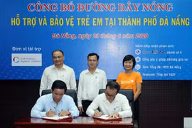 Đại diện Tổng đài 1022 và Trung tâm Cung cấp dịch vụ Công tác xã hội Đà Nẵng ký kết Quy chế phối hợp. (Ảnh: Trần Lê Lâm/TTXVN)