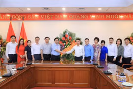 Thứ trưởng Bộ Văn hóa, Thể thao và Du lịch Tạ Quang Đông (bên trái) chúc mừng Thông tấn xã Việt Nam. (Ảnh: Dương Giang/TTXVN)