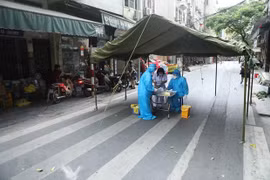 Nhân viên y tế quận Hoàn Kiếm lấy mẫu xét nghiệm COVID-19 cho các trường hợp có nguy cơ cao. (Ảnh: TTXVN)