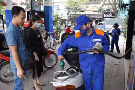 Nhân viên Petrolimex đang bán xăng cho khách hàng. (Ảnh: Đức Duy/Vietnam+)