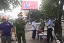 Lực lượng chức năng của Hà Nội xử phạt người không đeo khẩu trang tại nơi công cộng. (Ảnh: Đức Duy/Vietnam+)