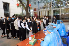 Nhân viên y tế lấy mẫu xét nghiệm các nhân viên Trung tâm Hội nghị Quốc gia tham gia phục vụ Đại hội XIII của Đảng, sáng 29/1. (Ảnh: TTXVN)