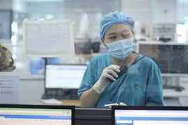 Nhân viên y tế tại khoa điều trị Bệnh viện điều trị bệnh nhân COVID-19 (thuộc Bệnh viện Đại học Y Hà Nội) liên hệ với nhân viên y tế phòng điều hành bằng bộ đàm đảm bảo an toàn, hạn chế sự lây lan của dịch COVID-19. (Ảnh: Minh Quyết/TTXVN)