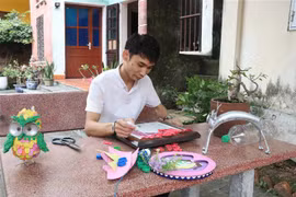Anh Giang sáng tạo tranh bằng những vật liệu bỏ đi. (Ảnh: Thanh Thương/TTXVN)