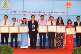 Thứ trưởng Bộ Giáo dục và Đào tạo Nguyễn Hữu Độ tặng Bằng khen của Bộ trưởng Bộ Giáo dục và Đào tạo cho các nhà giáo tiêu biểu. (Ảnh: Thanh Tùng/TTXVN)