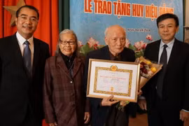 Trao tặng Huy hiệu 70 năm tuổi Đảng cho đảng viên lão thành Lê Xuân Bá. (Ảnh: Hồng Kỳ/Vietnam+)