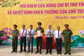 Bí thư Tỉnh ủy Đồng Nai Nguyễn Phú Cường trao thư khen lực lượng Công an Đồng Nai liên tiếp triệt phá thành công 2 chuyên án quan trọng. (Ảnh: Lê Xuân/TTXVN)