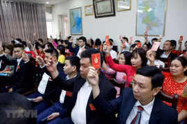 Các đại biểu biểu quyết thông qua Nghị quyết của Đại hội Đảng bộ. (Ảnh: Phạm Kiên/TTXVN)