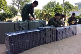 Tổ công tác thuộc Đồn Biên phòng Phước Chỉ kiểm đếm số thuốc lá ngoại thu giữ. (Ảnh: TTXVN phát)