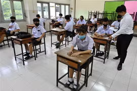 Học sinh và giáo viên đeo khẩu trang phòng lây nhiễm COVID-19 tại một trường học ở Bangkok, Thái Lan. (Ảnh: AFP/TTXVN)