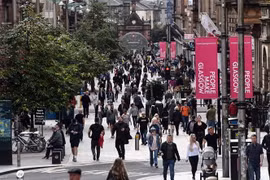 Người dân di chuyển trên đường phố tại Glasgow, Anh. (Ảnh: AFP/TTXVN)