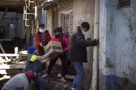 Tình nguyện viên phân phát lương thực cứu trợ do dịch COVID-19 cho người dân tại Buenos Aires, Argentina. (Ảnh: AFP/TTXVN)