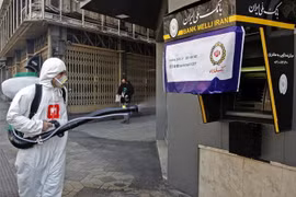 Phun thuốc khử trùng nhằm ngăn chặn sự lây lan của dịch COVID-19 tại Tehran, Iran. (Ảnh: AFP/TTXVN)