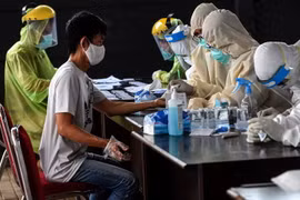 Nhân viên y tế lấy mẫu xét nghiệm COVID-19 tại chợ ở Banten, Indonesia. (Ảnh: THX/TTXVN)