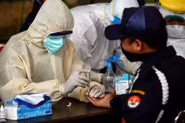 Nhân viên y tế lấy mẫu xét nghiệm nhanh COVID-19 tại một chợ ở Banten, Indonesia. (Ảnh: THX/TTXVN)