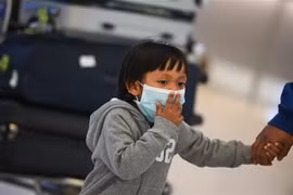 Một em nhỏ đeo khẩu trang phòng dịch COVID-19 tại Los Angeles, Mỹ. (Ảnh: AFP/TTXVN)