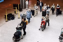 Hành khách đeo khẩu trang phòng lây nhiễm COVID-19 tại sân bay Helsinki-Vantaa, Phần Lan. (Ảnh: AFP/TTXVN)