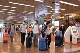 Đeo khẩu trang để phòng tránh lây nhiễm COVID-19 tại sân bay quốc tế Changi, Singapore. (Ảnh: AFP/TTXVN)