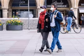 Người dân đeo khẩu trang phòng dịch COVID-19 khi di chuyển trên phố ở Munich, Đức. (Ảnh: THX/TTXVN)