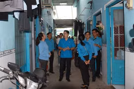 Lãnh đạo Liên đoàn Lao động Tp. Hồ Chí Minh thăm, chúc Tết chủ nhà trọ và công nhân lao động có hoàn cảnh khó khăn không có điều kiện về quê đón Tết. (Ảnh: Thanh Vũ/TTXVN)