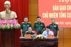 Đại tướng Lương Cường và Thượng tướng Trịnh Văn Quyết ký biên bản bàn giao (Ảnh: Hồng Pha/TTXVN phát)