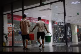 Xách nước như thời... bao cấp tại khu đô thị Nam An Khánh, Hà Nội đêm 15/10. (Ảnh: Minh Sơn/Vietnam+) 