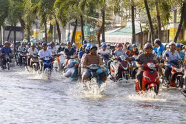 Triều cường gây ngập sâu trên đường Mậu Thân, quận Ninh Kiều khiến việc đi lại của người dân gặp khó khăn. (Ảnh: Thanh Liêm/TTXVN)