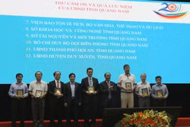 Lãnh đạo tỉnh Quảng Nam tặng quà lưu niệm cho các tổ chức quốc tế làm tốt công tác bảo tồn di sản. (Ảnh Trần Tĩnh/TTXVN)