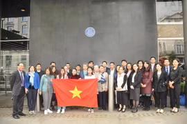 Cán bộ, nhân viên Đại sứ quán, các cơ quan đại diện Việt Nam, học sinh, sinh viên cùng đại diện bà con Việt kiều tại Anh chụp ảnh kỷ niệm dưới Biển tưởng niệm Bác Hồ tại Tòa nhà New Zealand. (Ảnh: Đình Thư/Vietnam+)