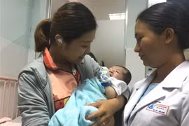 Niềm vui của gia đình bệnh nhân sau khi bé được phẫu thuật và hồi phục. (Ảnh: Đinh Hằng/TTXVN)