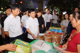 Ông Ngô Văn Quý, Phó Chủ tịch Ủy ban Nhân dân thành phố Hà Nội cùng các đại biểu tham quân các gian hàng ẩm thực. (Ảnh: Thành Đạt/TTXVN)