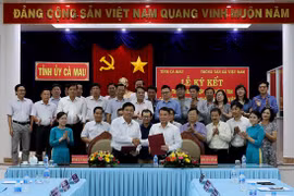 Tổng Giám đốc TTXVN Nguyễn Đức Lợi và Chủ tịch Ủy ban Nhân dân tỉnh Cà Mau Nguyễn Tiến Hải ký kết thỏa thuận hợp tác truyền thông. (Ảnh: Kim Há/TTXVN)