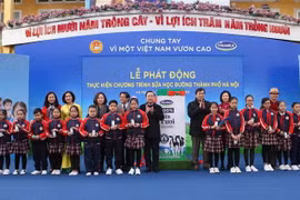 Tặng sữa cho các học sinh tại buổi lễ. (Ảnh: Thanh Tùng/TTXVN)