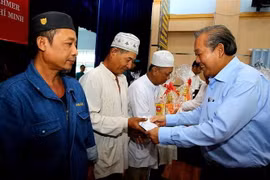 Phó Thủ tướng Trương Hòa Bình trao quà cho đồng bào dân tộc Chăm ở Thành phố Hồ Chí Minh. (Ảnh: Thành Chung/TTXVN)