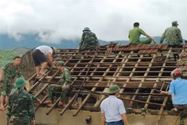 Hơn 250 cán bộ chiến sỹ công an, quân đội có mặt hỗ trợ nhân dân thôn Hoa Tiến (xã Kỳ Hoa, thị xã Kỳ Anh, Hà Tĩnh) lợp lại mái nhà. (Ảnh: Hoàng Ngà/TTXVN)