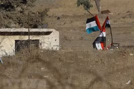 Quốc kỳ Syria được treo gần khu định cư Ein Zivan trên Cao nguyên Golan năm 2018. (Nguồn: AFP/TTXVN)