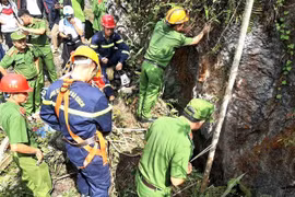 Lực lượng cứu hộ tìm kiếm thi thể nạn nhân. (Ảnh: TTXVN phát)