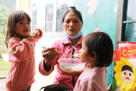 Chăm lo cho trẻ em tại điểm sơ tán cho người dân tránh bão. (Ảnh: Phạm Cường/TTXVN)