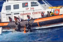 Tàu của Lực lượng Bảo vệ Bờ biển Italy giải cứu người di cư và tìm kiếm thi thể các nạn nhân ở ngoài khơi đảo Lampedusa, ngày 5/8. (Ảnh: AFP/TTXVN)
