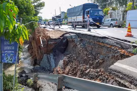 Tình trạng sạt lở bờ sông ảnh hưởng đến mặt đường nhựa Quốc lộ 80. (Ảnh: TTXVN phát)