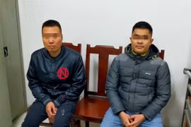 Hai đối tượng bị triệu tập làm việc tại cơ quan công an. (Ảnh: TTXVN phát)