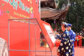 Nhà thư pháp Nguyễn Đình Kế, Câu lạc bộ thư pháp Hán Nôm tỉnh Hải Dương đã trình diễn khai bút Hán văn với chủ đề Quốc thái dân an. (Ảnh: Mạnh Minh/TTXVN)