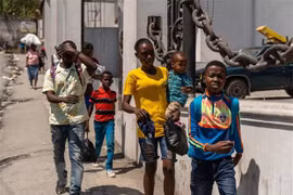 Người dân rời bỏ nhà cửa sau cuộc tấn công của bang nhóm tội phạm tại Port-au-Prince, Haiti. (Ảnh: AFP/TTXVN) 