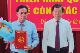 Bí thư Tỉnh ủy Đồng Nai Nguyễn Hồng Lĩnh trao quyết định và tặng hoa chúc mừng ông Võ Tấn Đức được giao làm quyền Chủ tịch UBND tỉnh Đồng Nai. (Ảnh: TTXVN phát) 