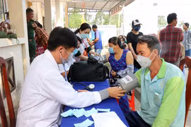 Khám bệnh miễn phí cho người dân vùng biên hoàn cảnh khó khăn. (Ảnh: Lê Huy Hải/TTXVN)